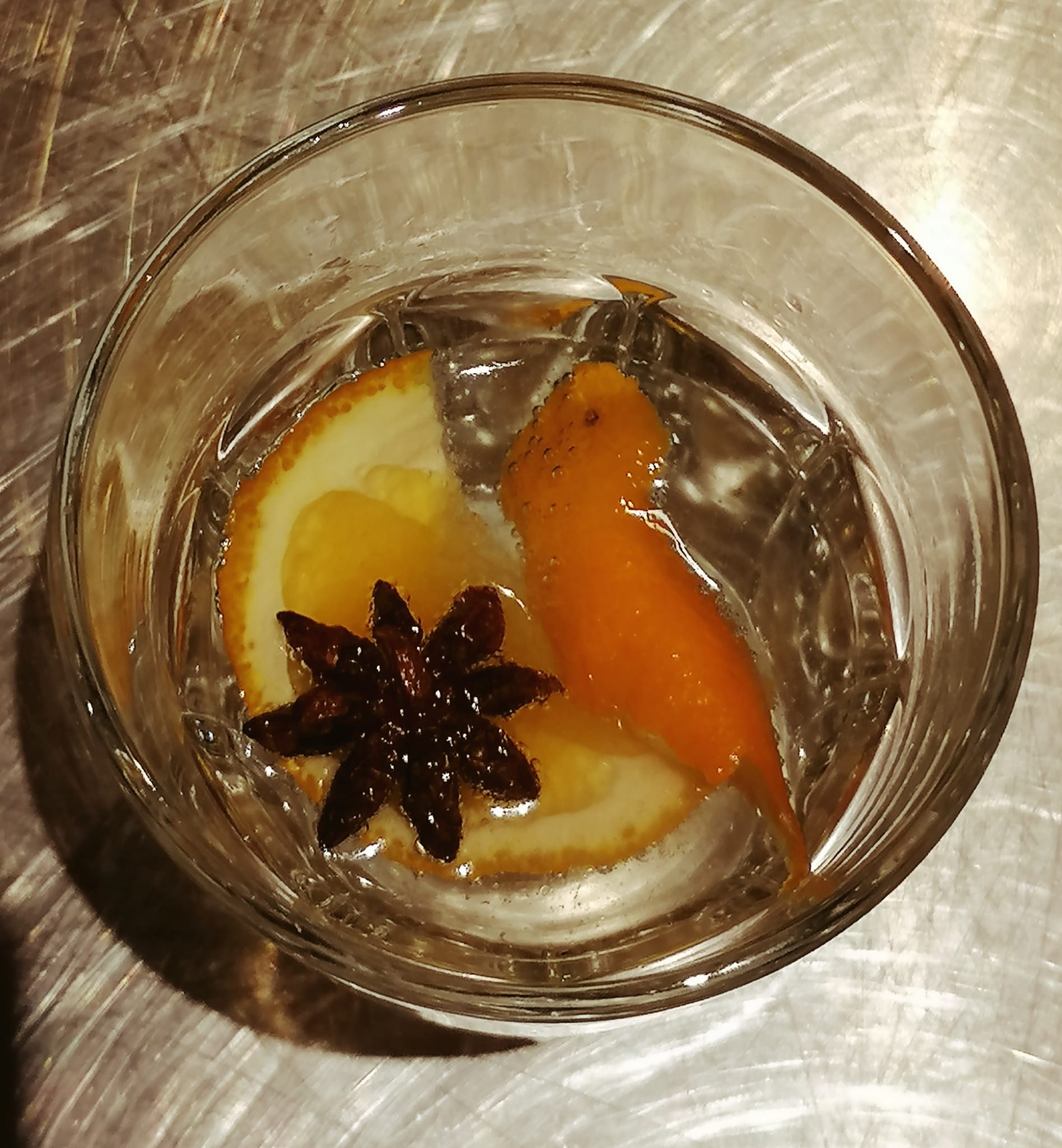 In einem Glas schwimmen Sternanis und eine Orangenschale